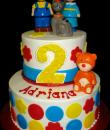Caillou 2nd Birthday Cake. White buttercream iced, round 2 tiers decorated with circles, Caillou, Rosie, Gilbert, and Teddy Bear. Everything on this cake is edible. (Plastic character figurines provided by client.) (Serves 28-55 party slices.) 