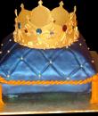 Crown Pillow Birthday Cake. Blue buttercream iced, pillow shaped cake decorated with tassels, pearls, and a jeweled crown. Everything on this cake is edible. 