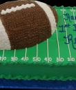 Football 1st Birthday Cake. Green buttercream iced, sheet cake decorated as the football field topped with a football shaped cake. Everything on this cake is edible. (Serves 24-98 party slices.) 