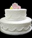White Elegance Birthday cake,  White textured buttercream iced, 2 round tiers. Topped with one yellow and one pink rose, each tier has a ruffle scalloped bottom and is adorned with pearls. Everything on this cake is EDIBLE.  (Serves 28-55 party slices)