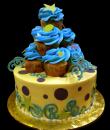 Cupcake Birthday Cake,  Yellow buttercream iced,  round decorated with stars, circles, dots and topped with a pyramid of cupcakes.  Everything on this cake is EDIBLE.  (Serves 8-80 party slices)