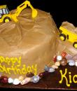 Dirty Jobs Birthday cake,  Chocolate buttercream iced,  round decorated with jelly bean rocks, a backhoe and dump truck.  Everything on this cake is EDIBLE.  (Figurine was provided by client). (Serves 8-80 party slices)