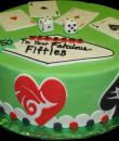 Fabulous 50's Birthday Cake, Green buttercream iced,  round cake decorated in a Las Vegas theme. Hearts, Spades, Clubs, and Diamonds adorn the side of this cake while dice and the Ace card from each suit sits atop. Poker chips and the Las Vegas themed welcome sign complete the look. Everything on this cake is EDIBLE.  (Serves 8-80 party slices)