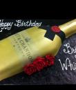 Champagne Bottle Birthday Cake,  Gold buttercream iced, sculpted moet and chandon champagne bottle cake elegantly decorated with red roses and a black ribbon. Everything on this cake is EDIBLE. 