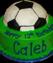 Soccer Ball 12th Birthday Cake. Green, black and white buttercream iced, round, decorated as a grassy field with a soccer ball. Everything on this cake is EDIBLE. (Serves 8-80 party slices) 