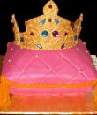 Tiara Pillow Birthday Cake. Pink buttercream iced, pillow shaped cake, decorated with tassels, and pearls. Topped with a golden jeweled tiara. Everything on this cake is edible. 